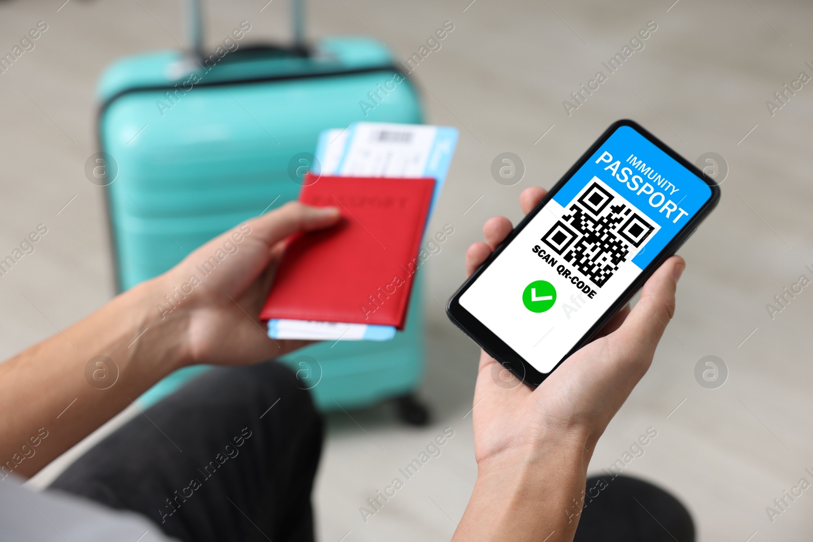 Image of Tourist with passport, flight tickets and mobile phone indoors, above view. Immunity passport app with QR code on device screen