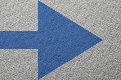 Image of One blue arrow on light grey textured background. Pointer