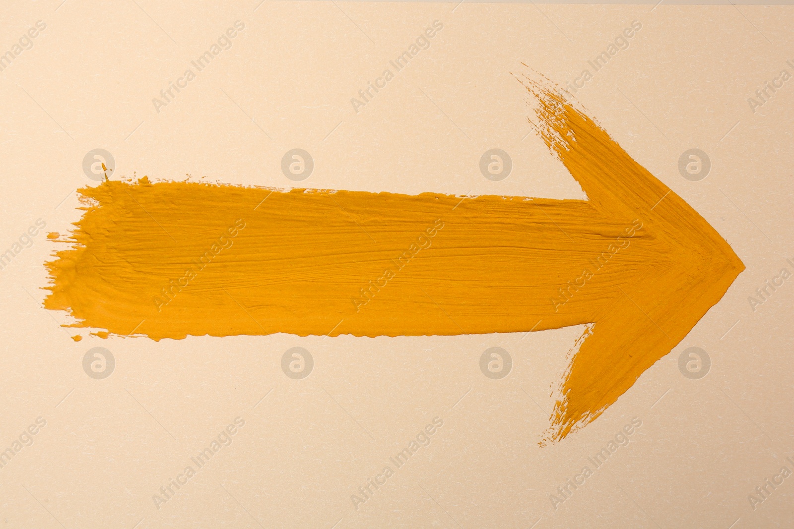 Image of One orange arrow on beige background. Pointer