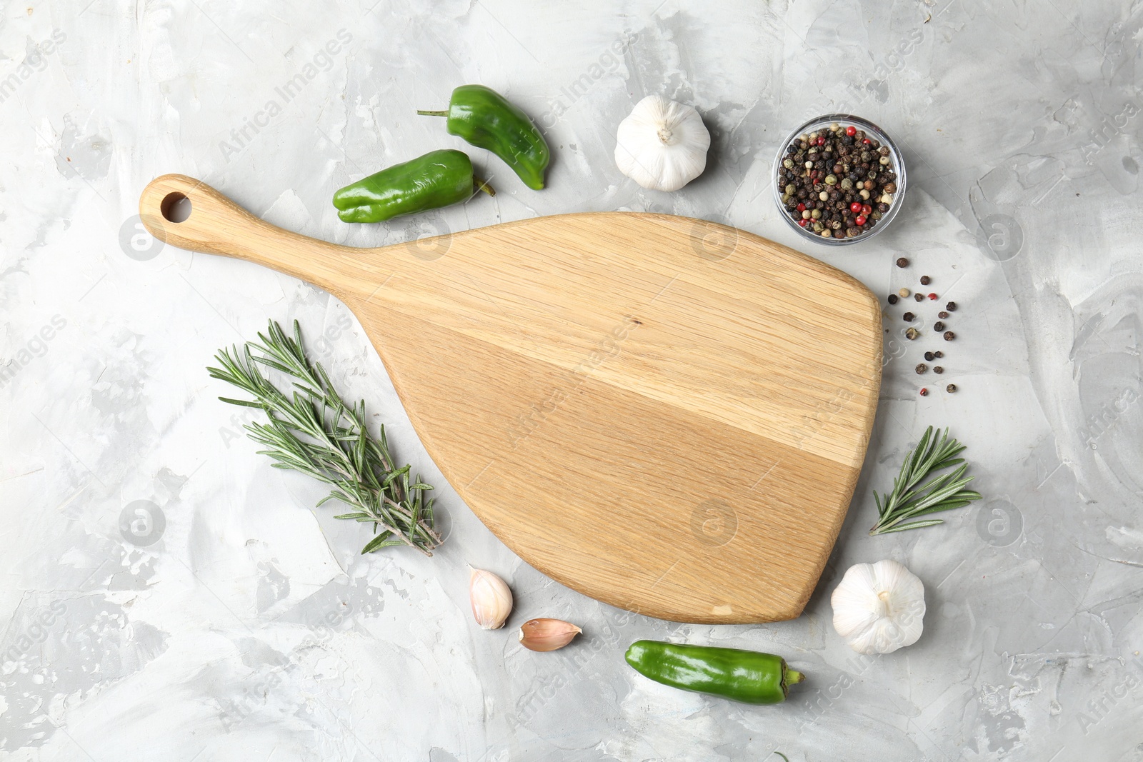 Photo of Cutting board with spices on grey textured table, flat lay