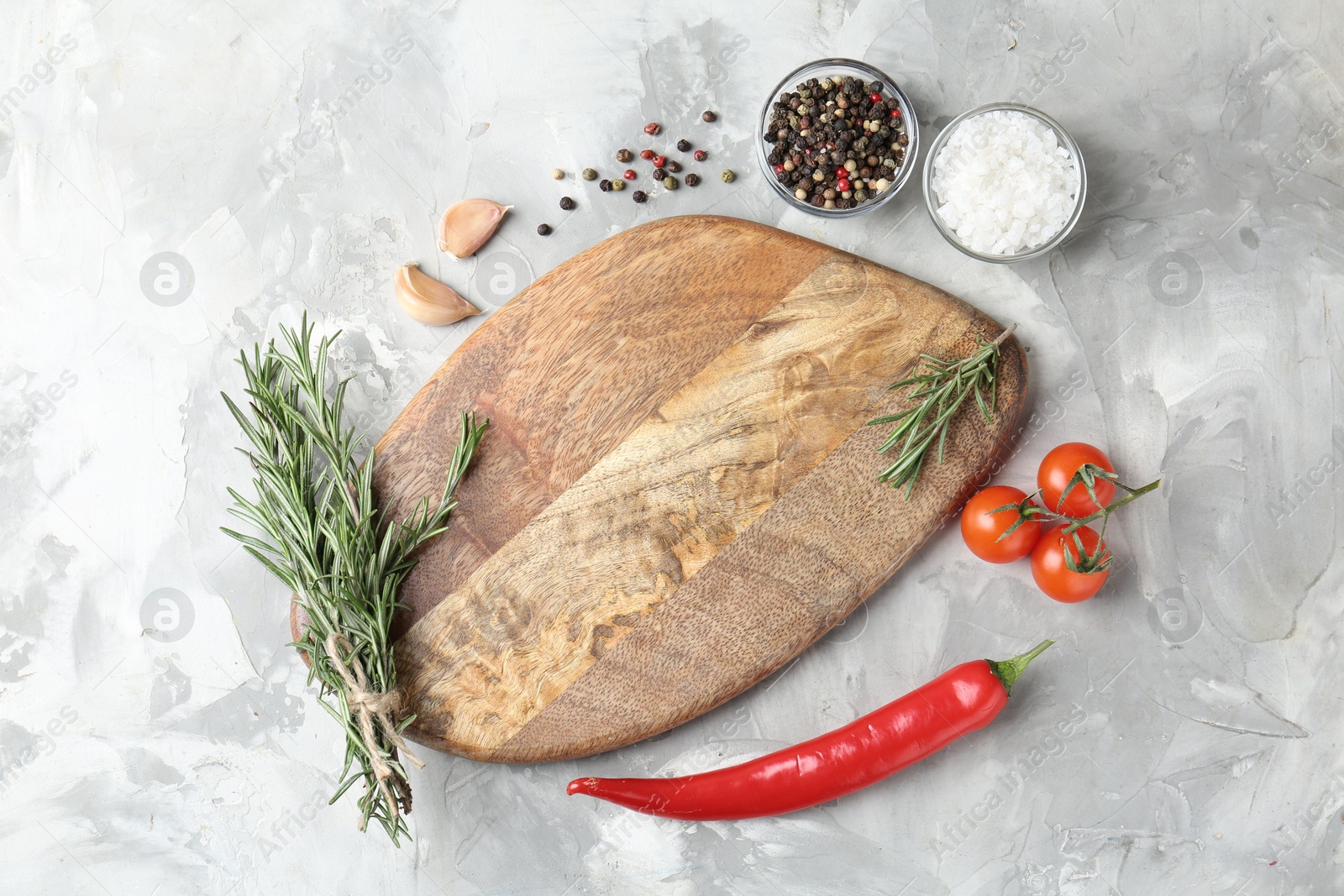 Photo of Cutting board with tomatoes and spices on grey textured table, flat lay