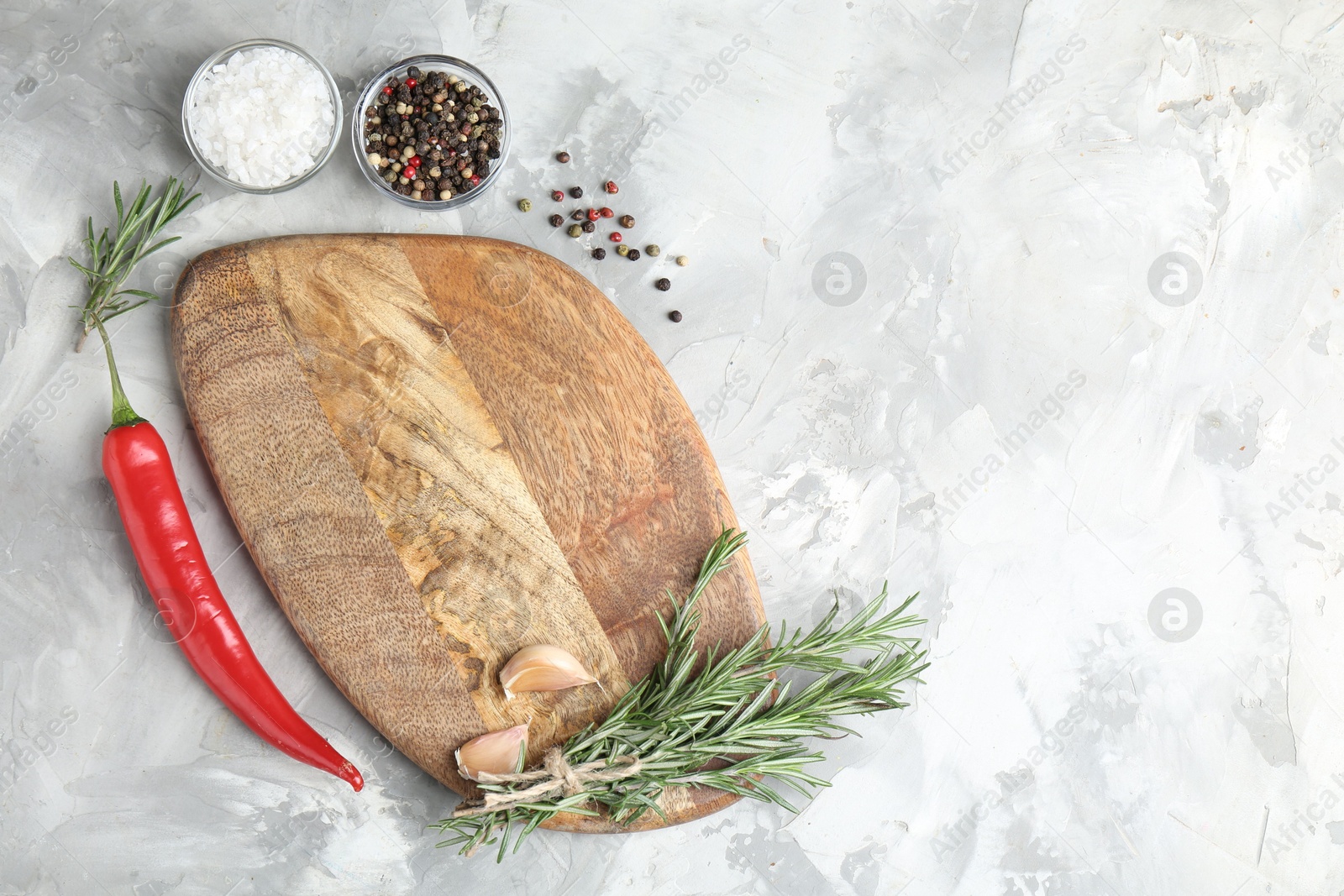 Photo of Cutting board with spices on grey textured table, flat lay. Space for text