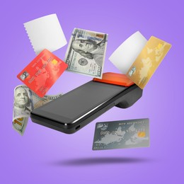 Image of Payment terminal, bank cards, dollars and receipt in air on violet background