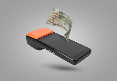 Image of Payment terminal and dollar in air on grey background