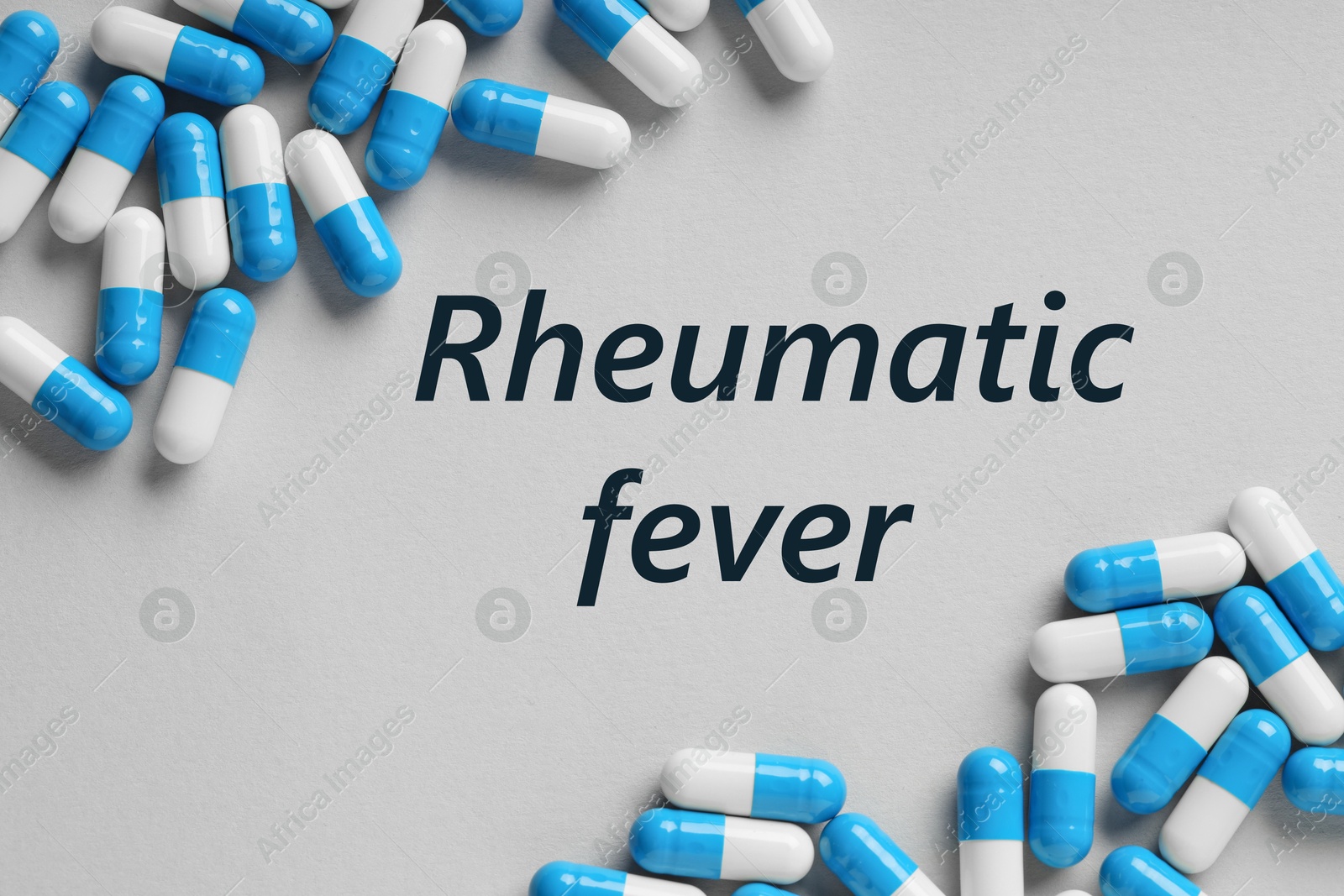 Image of Rheumatism. Pills and word Rheumatic Fever on grey background, top view