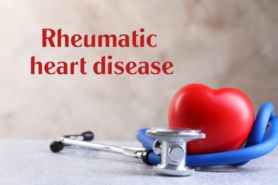 Image of Rheumatism. Stethoscope, red heart and words Rheumatic Heart Disease on blurred background