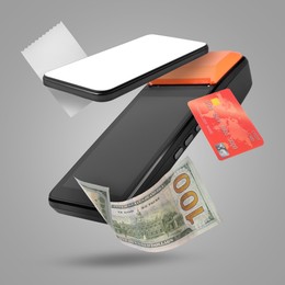 Image of Payment terminal, bank card, dollar, mobile phone and receipt in air on grey background