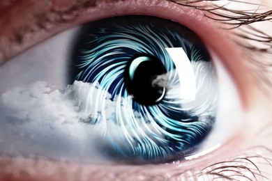 Image of Hypnosis. Hypnotic spiral and clouds in woman's eye, closeup