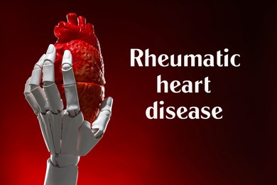 Image of Rheumatism. Robot hand holding model of human heart on red gradient background with words Rheumatic Heart Disease