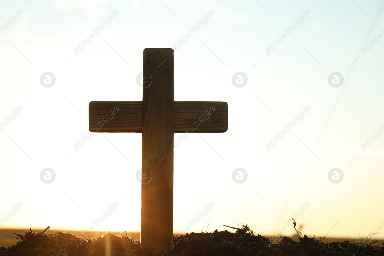 Photo of Wooden Christian cross outdoors at sunrise, space for text. Religion concept