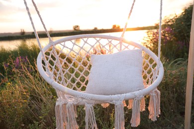 Photo of Beautiful white swing chair outdoors at sunrise