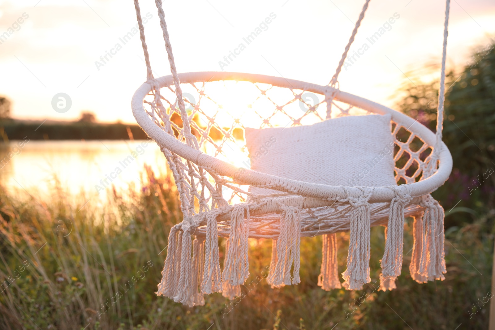 Photo of Beautiful white swing chair outdoors at sunrise