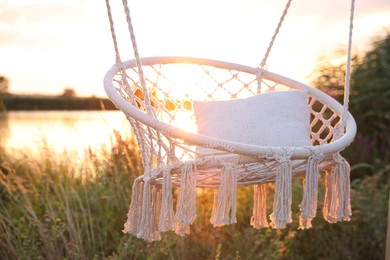 Photo of Beautiful white swing chair outdoors at sunrise