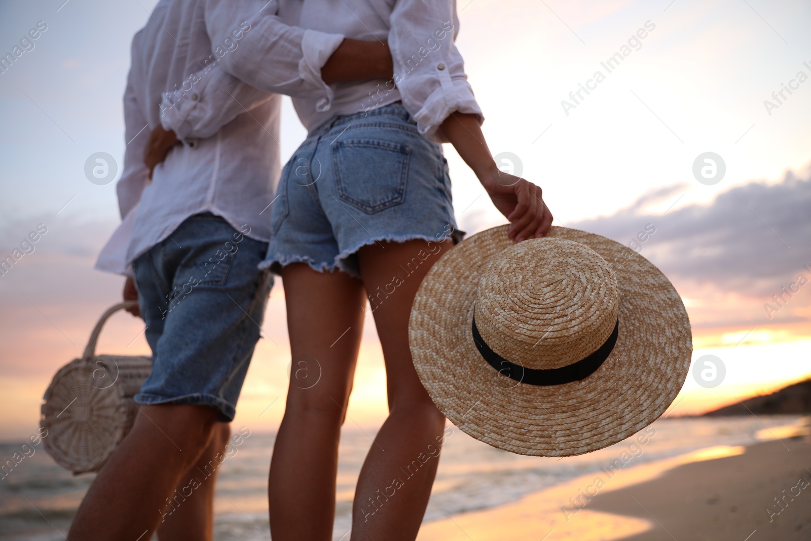 Photo of Lovely couple walking on beach at sunset, closeup