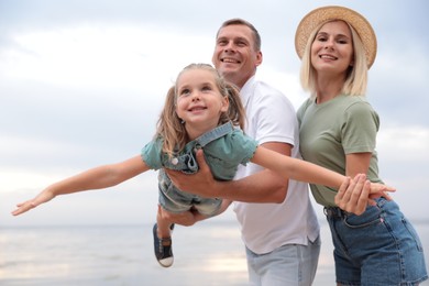 Photo of Happy family spending time together near sea on sunny summer day