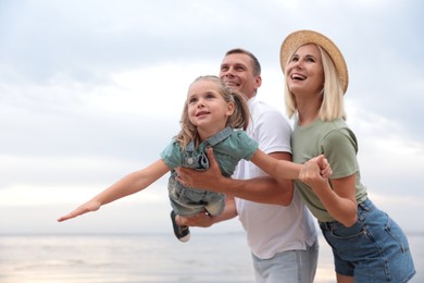 Photo of Happy family spending time together near sea on sunny summer day