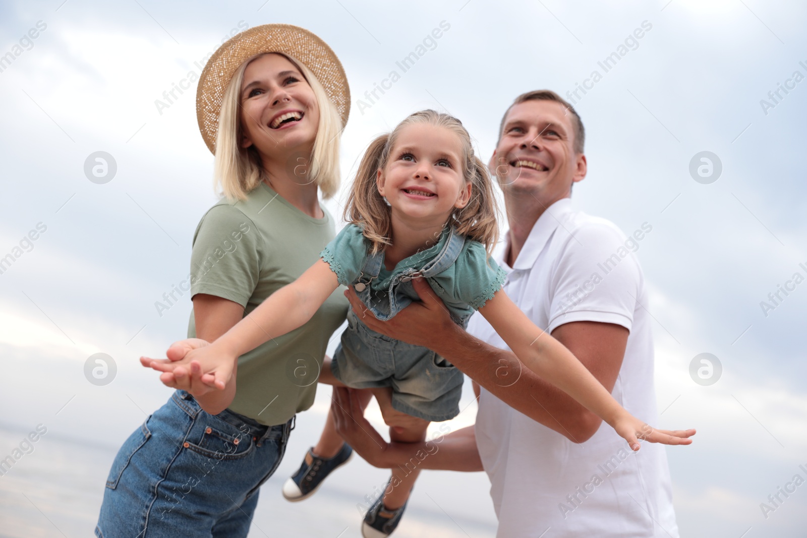 Photo of Happy family spending time together near sea on sunny summer day