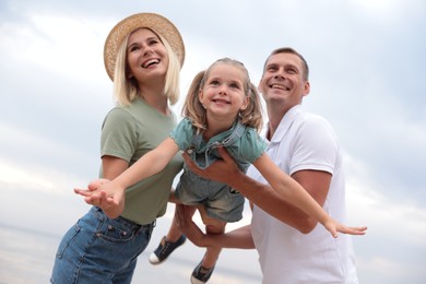 Photo of Happy family spending time together near sea on sunny summer day