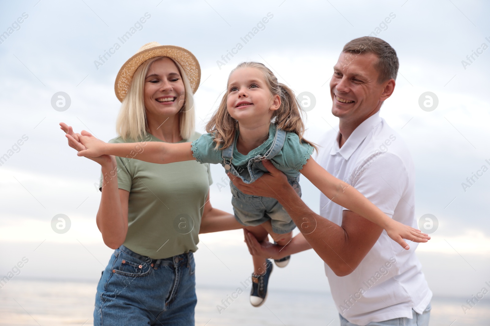 Photo of Happy family spending time together near sea on sunny summer day