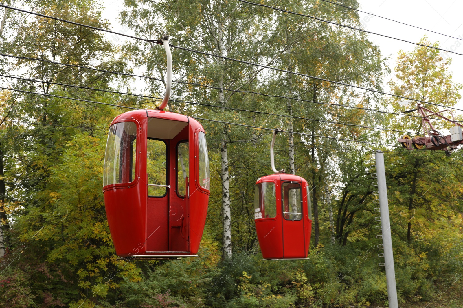 Photo of View of cableway with bright cabins in park on autumn day