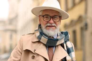 Photo of Portrait of elegant senior man in hat outdoors