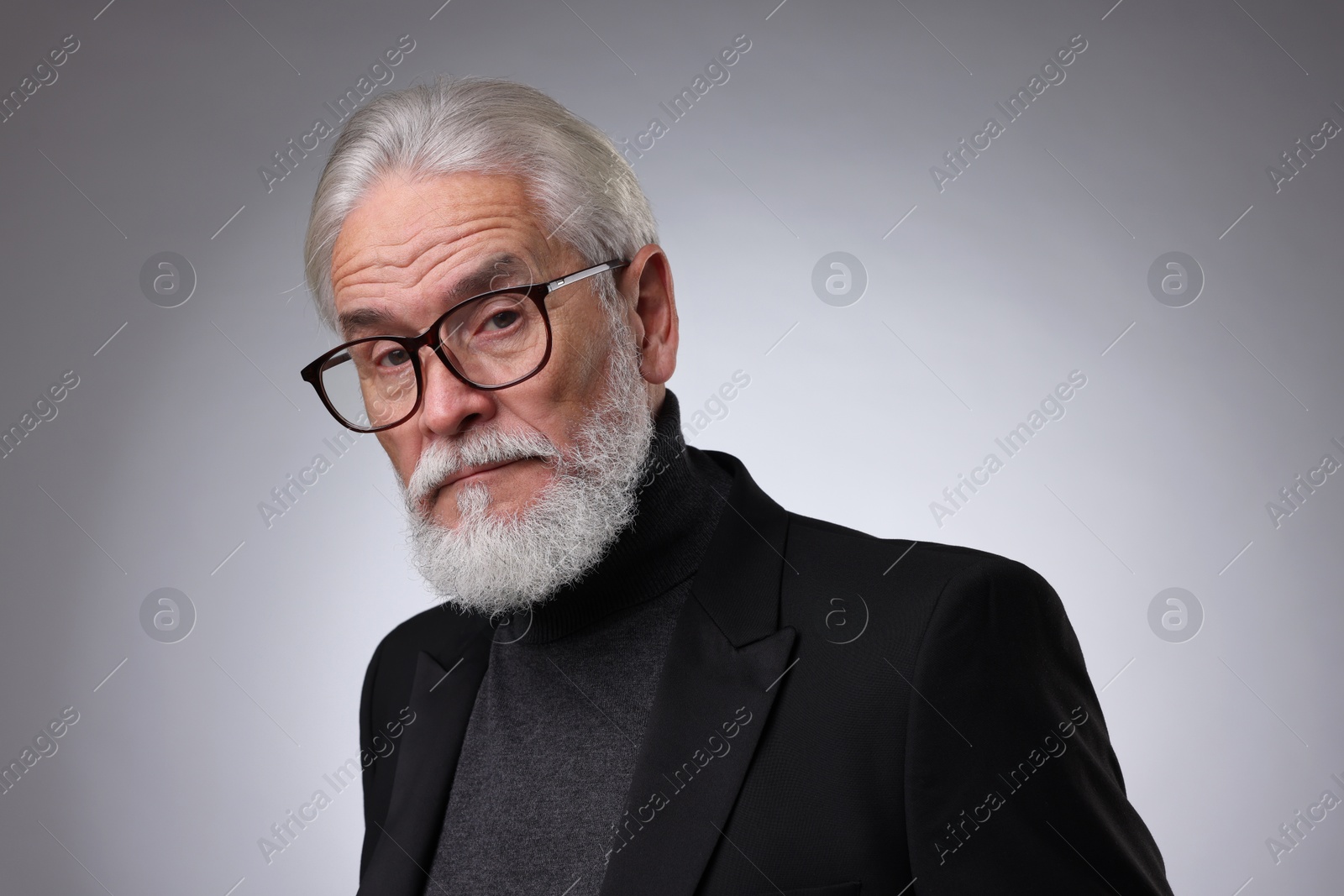 Photo of Portrait of confident senior man with silver beard on light grey background