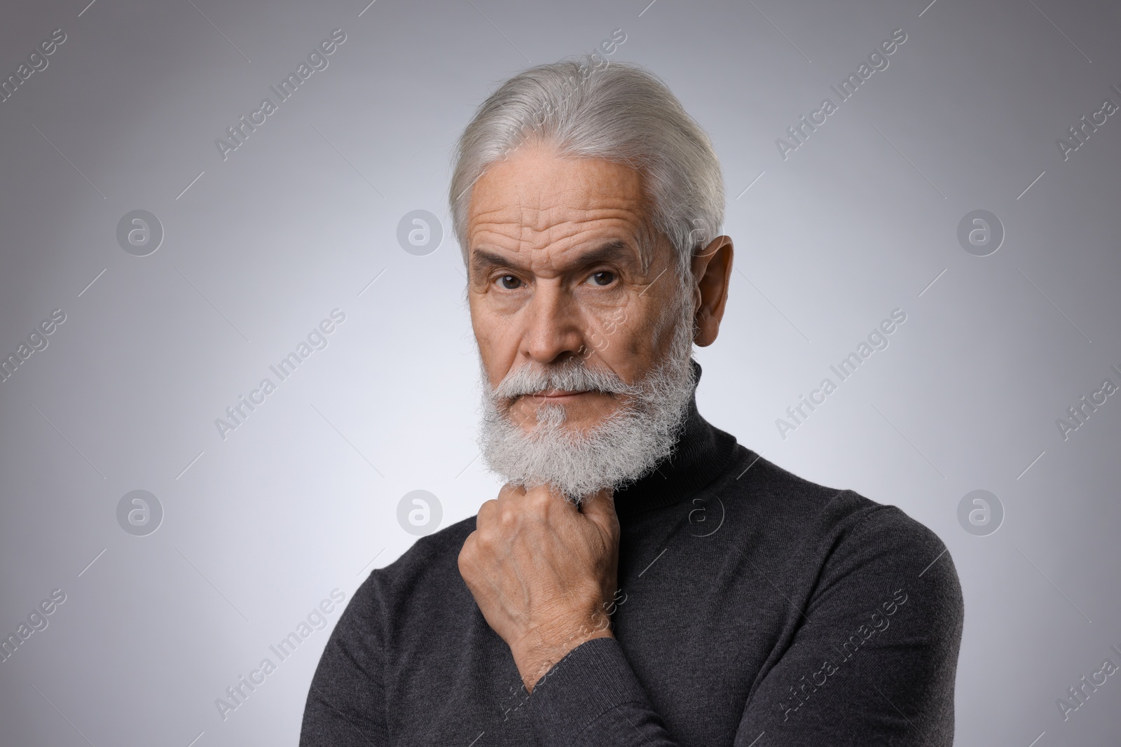 Photo of Portrait of confident senior man with silver beard on light grey background