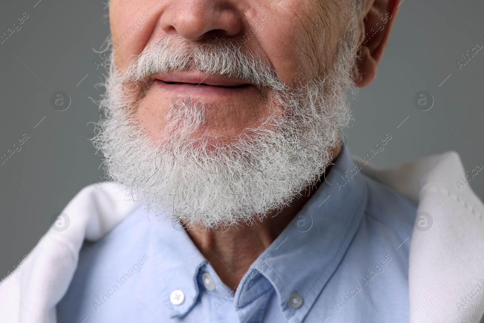 Photo of Senior man with gray beard on grey background, closeup