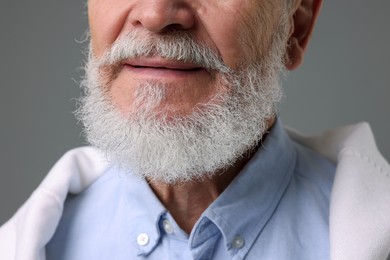 Photo of Senior man with gray beard on grey background, closeup