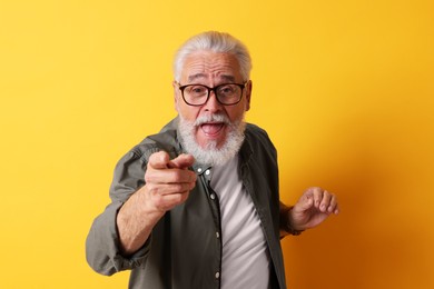 Photo of Emotional senior man with beard on orange background