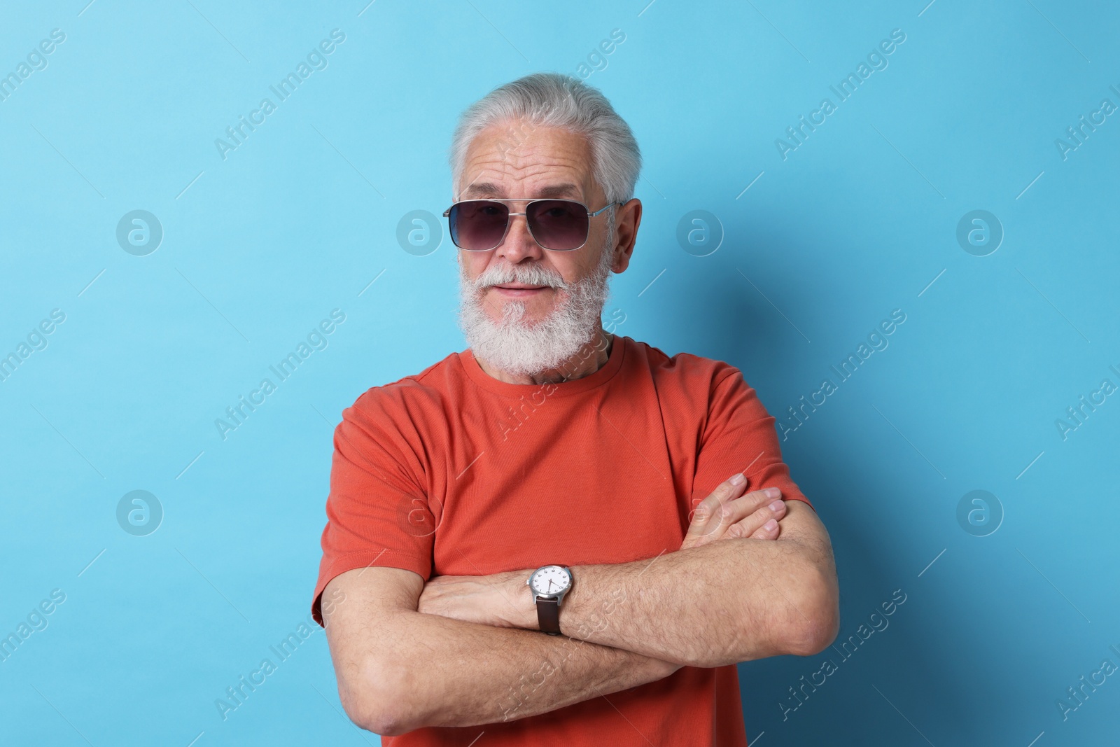 Photo of Senior man in sunglasses on light blue background