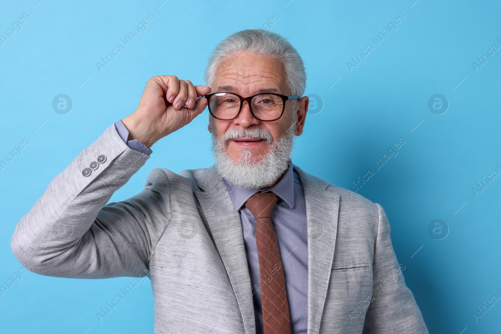 Photo of Portrait of senior man with gray beard on light blue background