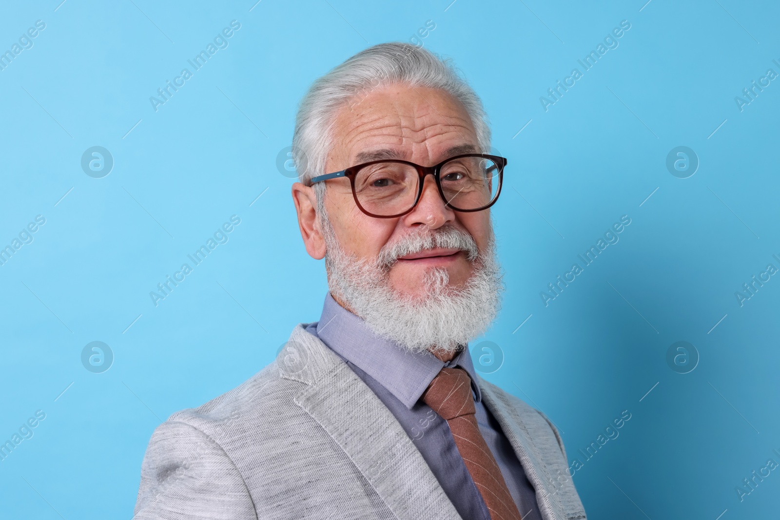 Photo of Portrait of senior man with gray beard on light blue background