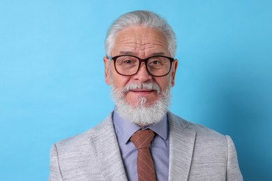 Photo of Portrait of senior man with gray beard on light blue background