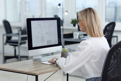 Photo of Technician making digital engineering drawing on computer at desk in office