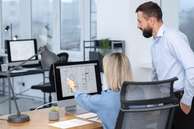 Photo of Technicians making digital engineering drawing on computer at desk in office