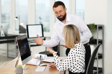 Photo of Technicians making digital engineering drawing on computer at desk in office