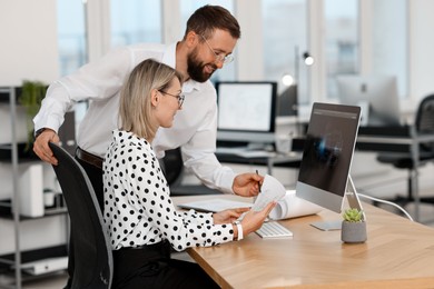 Technicians making digital engineering drawing on computer at desk in office