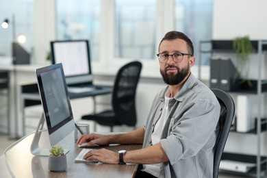 Photo of Technician making digital engineering drawing on computer at desk in office