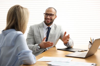 Photo of Coworkers working together at table in office