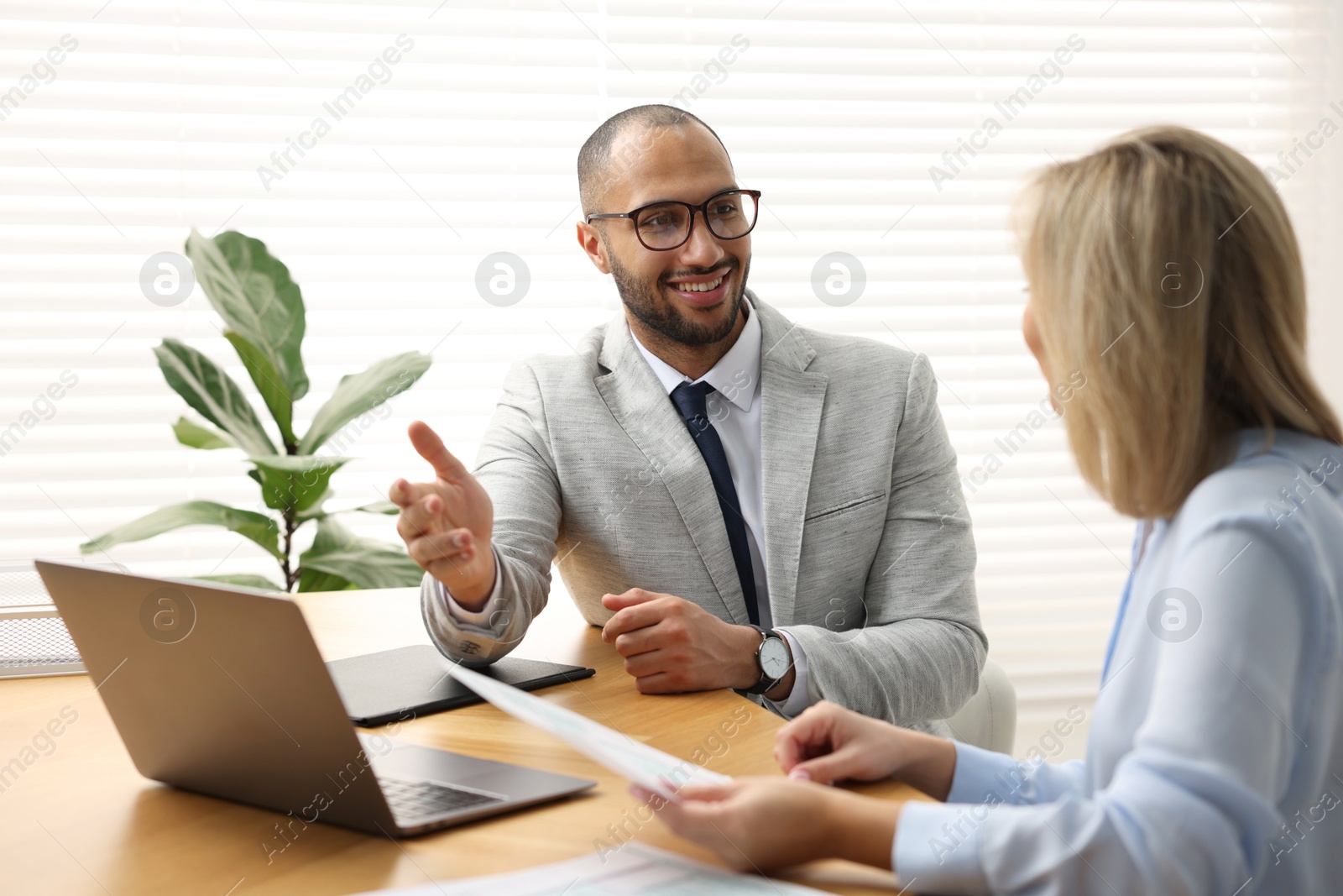 Photo of Coworkers working together at table in office