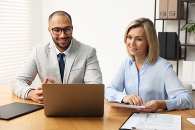 Photo of Coworkers with laptop working together in office