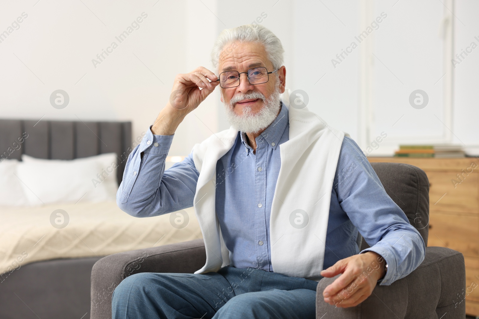 Photo of Handsome bearded man in armchair at home