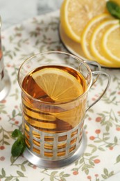 Glass of tea in metal holder served on table, closeup