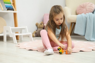 Photo of Little girl playing with toys near step stool at home