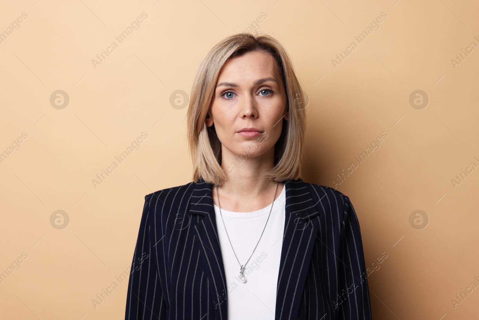 Photo of Portrait of businesswoman in jacket on beige background