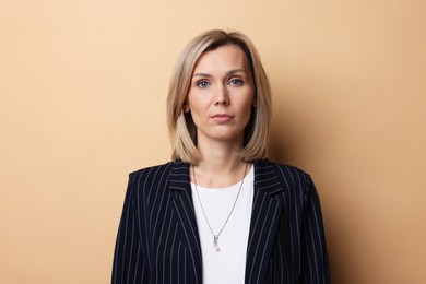 Photo of Portrait of businesswoman in jacket on beige background