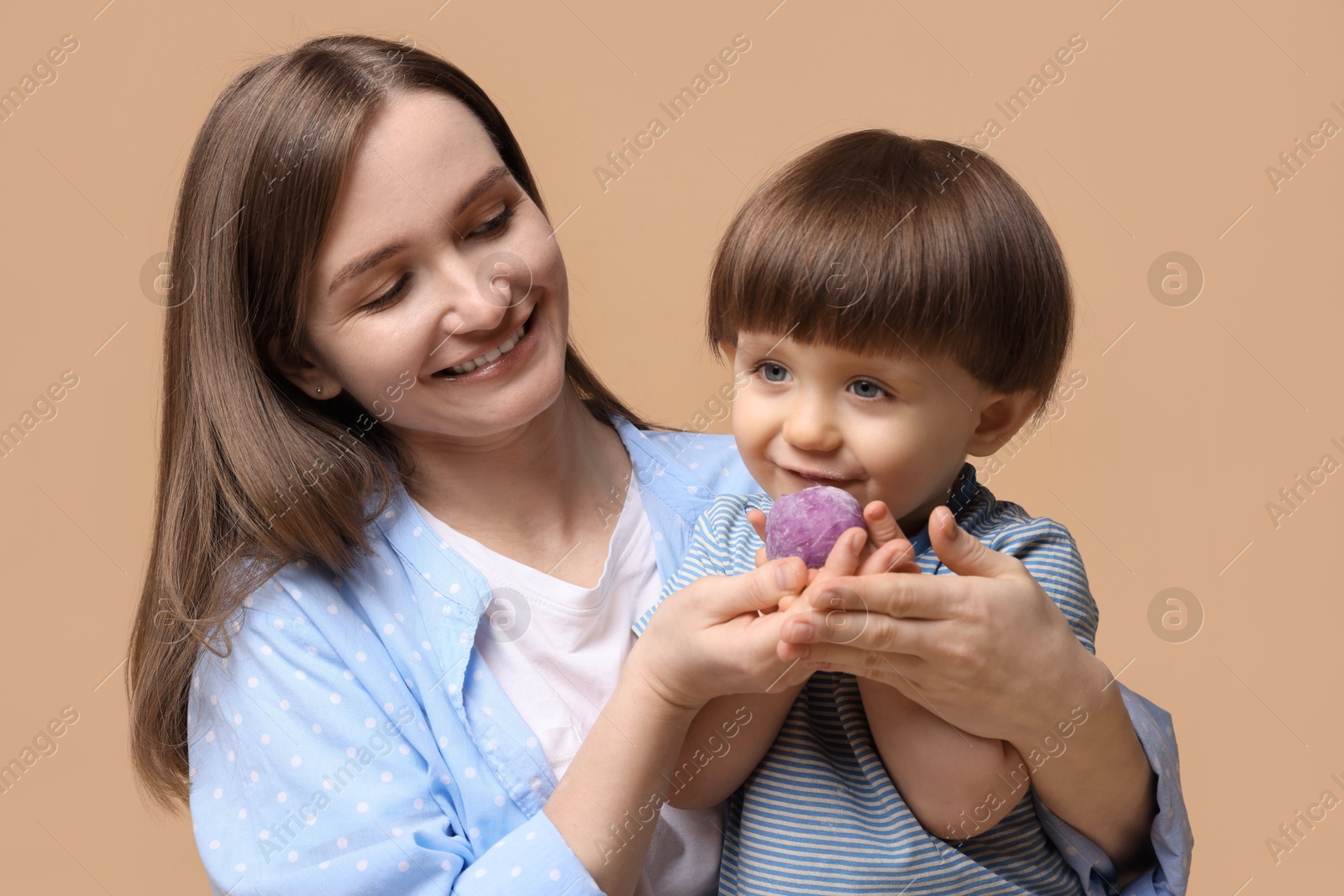 Photo of Mother and baby eating tasty mochi on brown background