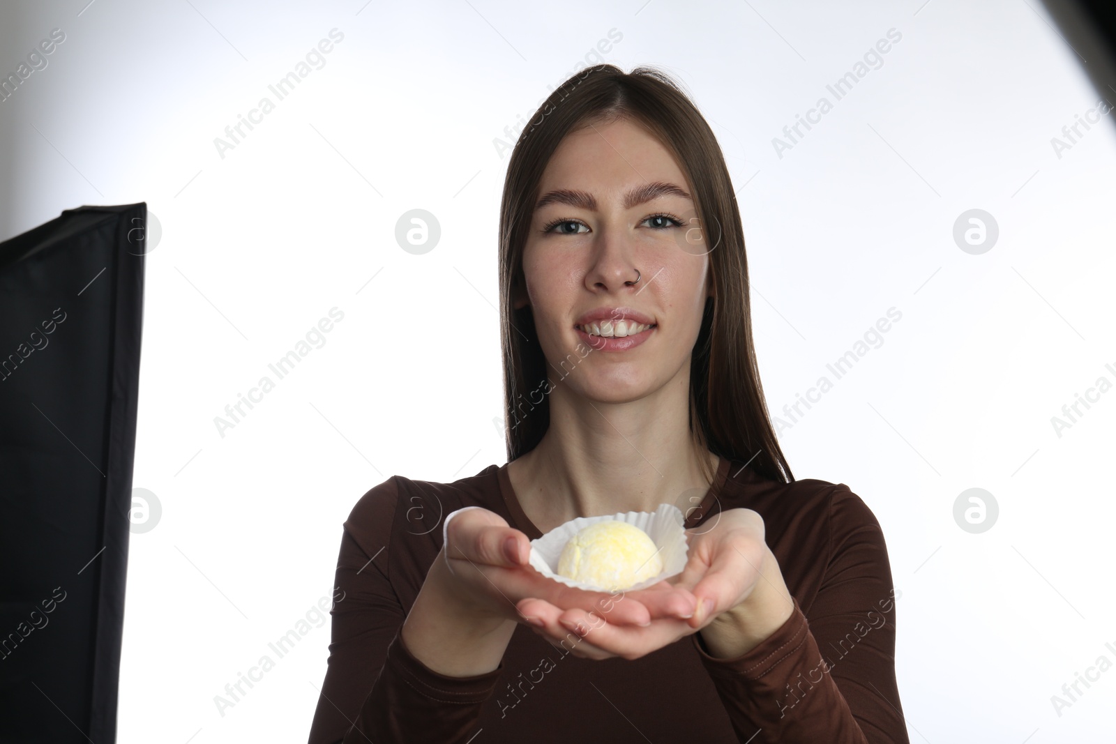 Photo of Smiling woman with tasty mochi on white background