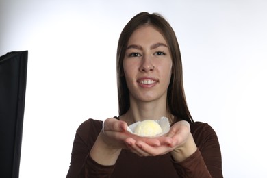 Photo of Smiling woman with tasty mochi on white background